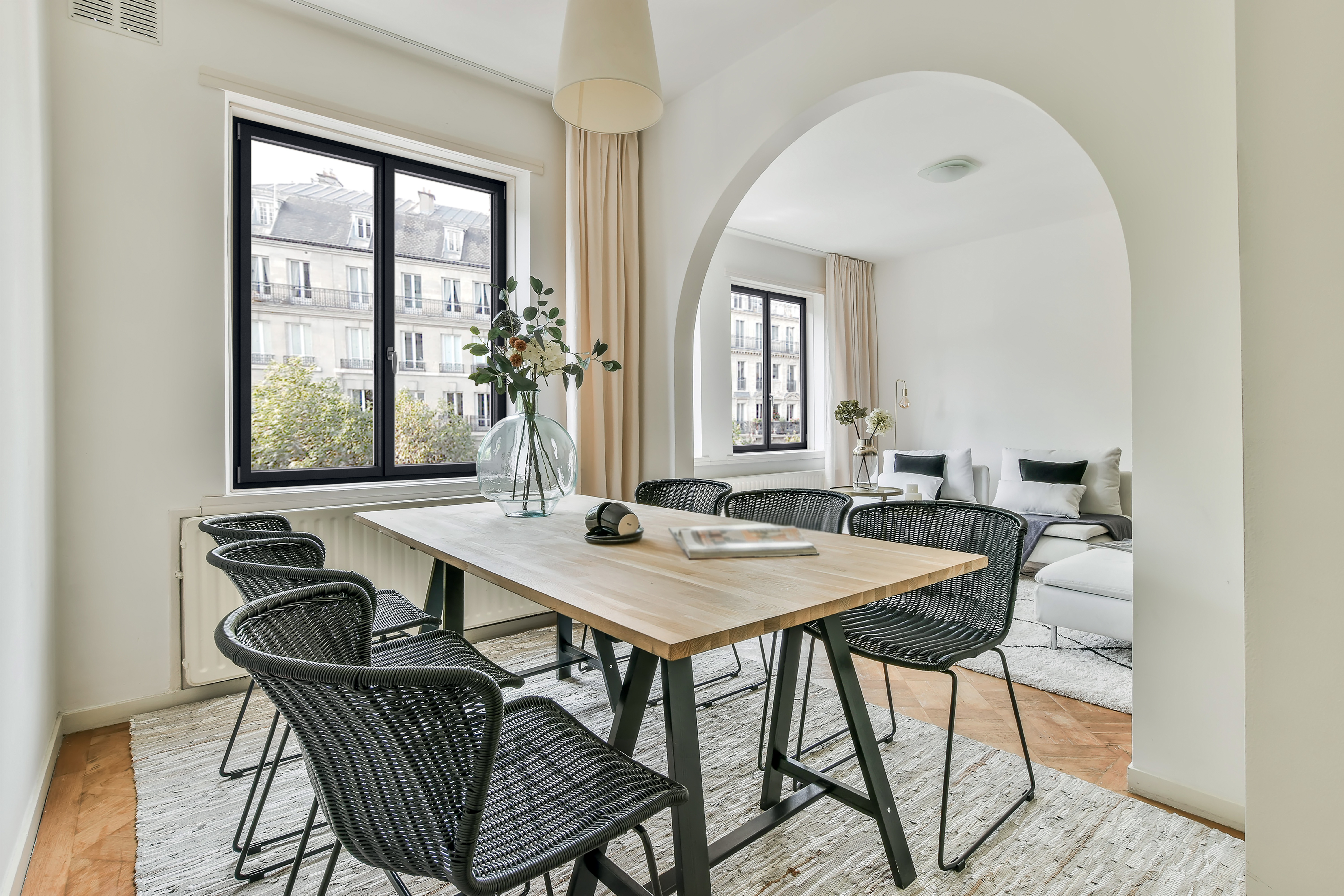 Image représentant le coin salon et salle à manger d'une maison. Les fenêtres en aluminium sont mise en valeur avec leur couleur gris anthracite.